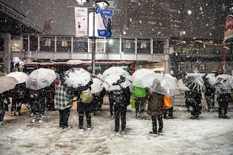 People are lining up with umbrellas to wait for the bus in heavy snow in the Shibuya district of Tokyo, on February 5. (Photo by Yusuke Harada/NurPhoto via Getty Images)