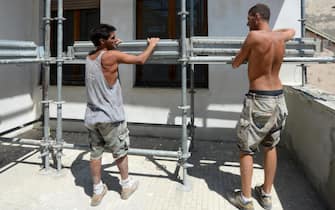 Due operai al lavoro in un cantiere edile a Pisa, 10 luglio 2012 . 
ANSA/FRANCO SILVI