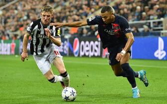 epa10900548 Anthony Gordon (L) of Newcastle in action against Kylian Mbappe of PSG during the UEFA Champions League Group F match between Newcastle United and Paris Saint-Germain in Newcastle, Britain, 04 October 2023.  EPA/PETER POWELL