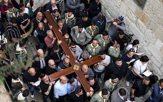 epa11249151 Christian faithful carry a cross during the Good Friday procession along the Via Dolorosa, towards the Church of the Holy Sepulchre in the Old city of Jerusalem, 29 March 2024. Christians of the Catholic and Western Christian churches around the world on 29 March commemorate Good Friday, the day when, according to the bible, Jesus was crucified by the Romans in Jerusalem.  EPA/ABIR SULTAN