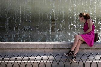 Una ragazza si rinfresca in una giornata di afa