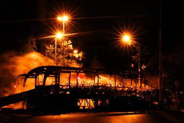 epa10720118 Firefighters extinguish a bus burned during clashes between protesters and riot police in Nanterre, near Paris, France, 30 June 2023. Violence broke out all over France after police fatally shot a 17-year-old teenager during a traffic stop in Nanterre on 27 June.  EPA/MOHAMMED BADRA