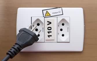 Type N Plug & Socket - a 3 plug socket primarily used in Brazil and South Africa, with a 110 Volt supply. Electrical equipment isolated against a plain wood background.