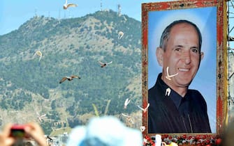 A portrait of Father Giuseppe "Pino" Puglisi, an outspoken anti-Mafia advocate, hangs over about 80,000 people during his beatification ceremony in Palermo on May 25, 2013. Puglisi was killed on his 56th birthday in the Brancaccio neighborhood in Palermo.      AFP PHOTO / MARCELLO PATERNOSTRO        (Photo credit should read MARCELLO PATERNOSTRO/AFP via Getty Images)