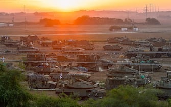 epa10924757 Israeli troops with a variety of military vehicles at a gathering site at an undisclosed location along the Israel-Gaza border, in southern Israel, 18 October 2023. Hundreds of people have been killed by an explosion at a crowded hospital in Gaza City late 17 October, health officials say.  EPA/HANNIBAL HANSCHKE