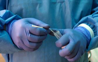 A health worker puts a swab sample in a vial to test for Covid-19. Photographer: T. Narayan/Bloomberg