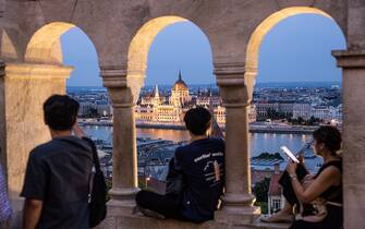 Tourists take in the view of the Hungarian parliament from Buda castle in Budapest, Hungary, on Tuesday, June 7, 2022. Inflation in Hungary exceeded 10% for the first time in more than 20 years, putting pressure on the central bank to tighten monetary policy further and prop up the forint. Photographer: Akos Stiller/Bloomberg via Getty Images