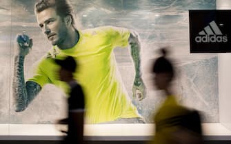 People walk past an Adidas AG advertisement featuring David Beckham inside Vincom Mega Mall Times City, operated by Vingroup JSC, in Hanoi, Vietnam, on Saturday, May 31, 2014. Vingroup is Vietnams largest property developer and mall operator. Photographer: Brent Lewin/Bloomberg via Getty Images