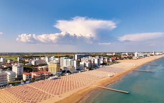 Spiaggia di Jesolo con lettini  e ombrelloni - vista aerea dall'alto con veduta sulla città