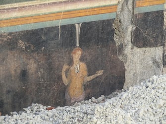 Un particolare dell'imponente salone da banchetto, dalle eleganti pareti nere decorate con soggetti mitologici ispirati alla guerra di Troia, tra gli ambienti recentemente portati alla luce durante le attività di scavo in corso nell'insula 10 della Regio IX di Pompei e oggi completamente visibile in tutta la sua maestosità. Un ambiente raffinato in cui il tema dominante delle decorazioni sembra essere quello dell'eroismo,  del fato e della possibilità che l'uomo ha di poter cambiare il proprio destino. Oltre a Elena e Paride, indicato in un'iscrizione greca tra le due figure con il suo altro nome 'Alexandros', appare sulle pareti del salone la figura di Cassandra, figlia di Priamo, in coppia con Apollo. Roma, 11 aprile 2024 ANSA/ Ufficio stampa del Ministero della cultura ANSA PROVIDES ACCESS TO THIS HANDOUT PHOTO TO BE USED SOLELY TO ILLUSTRATE NEWS REPORTING OR COMMENTARY ON THE FACTS OR EVENTS DEPICTED IN THIS IMAGE; NO ARCHIVING; NO LICENSING NPK