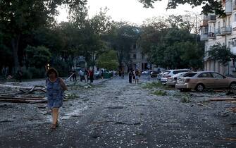 Local residents stand among the debris in the street after a missile strike in Odesa, early on July 23, 2023. At least one person was killed and more than 15 wounded in a Russian attack on the southern Ukrainian port city of Odesa, the governor of the region said. (Photo by Oleksandr GIMANOV / AFP) (Photo by OLEKSANDR GIMANOV/AFP via Getty Images)