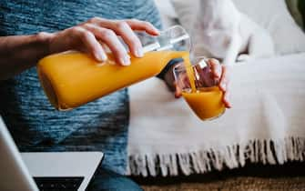 man at home serving orange juice, Madrid, Spain