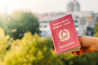 Someone holding an Italian passport with an urban background. Italy is part of the European Union