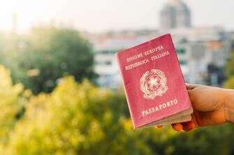 Someone holding an Italian passport with an urban background. Italy is part of the European Union