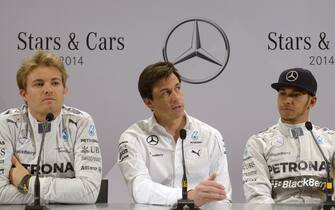Mercedes-AMG's F1 British driver Lewis Hamilton (R) and his German teammate Nico Rosberg (L) attend a press conference with Mercedes AMG Executive Director Torger Christian "Toto" Wolff (C) at the Mercedes-Benz "Stars & Cars 2014" event in Stuttgart, southwestern Germany, on November 29, 2014.  AFP PHOTO / THOMAS KIENZLE        (Photo credit should read THOMAS KIENZLE/AFP/Getty Images)