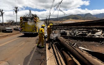 epa10796011 Firefighters put out a pocket of fire still burning in a neighborhood destroyed by a wild fire in Lahaina, Hawaii, USA, 11 August 2023. At least 67 people were killed in the wildfires burning in Maui, which is considered the largest natural disaster in Hawaii's state history.  EPA/ETIENNE LAURENT