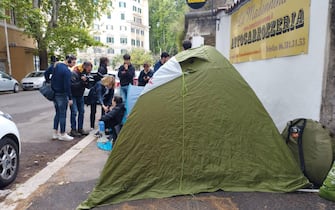 Alcuni studenti dentro una tenda da campeggio hanno montato dei cartelli di protesta contro il caro affitt  davanti al Miur a Roma, 11 maggio 2023.
ANSA/Cecilia Ferrara