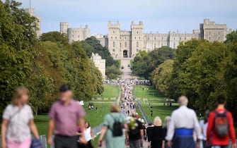 epa10179761 People on the Long Walk with Windsor Castle in the background in Windsor, Britain, 12 September 2022. Britain's Queen Elizabeth II died on 08 September 2022. The 96-year-old queen was the longest-reigning monarch in British history.  EPA/NEIL HALL