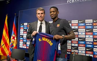 epa06088013 FC Barcelona's new signed player Nelson Semedo (R) and FC Barcelona's Sports Manager Robert Fernandez (L) pose with his jersey as Semedo is presented as new player durign a press conference at Camp Nou stadium in Barcelona, Catalonia, Spain, 14 July 2017. Barcerlona signed right-back Semedo from Portuguese club Benfica for an reported 30 million euro.  EPA/QUIQUE GARCIA
