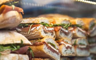 Panini (sandwiches) made of arugula, tomato and prosciutto crudo (raw ham) in a store in Venice, Veneto region, Italy.