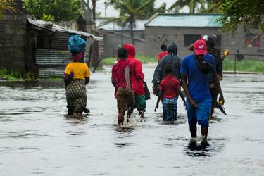 epa10515448 Locals passes on a flooded street near Quelimane, as the storm Freddy hits Mozambique, 11 March 2023. The provincial capital of Quelimane will be the largest urban area closest to the cyclone's point of arrival on the mainland, and its radius (of about 300 kilometres) is expected to extend from Marromeu to Pebane, then moving inland towards Cherimane and southern Malawi. This is one of the longest lasting storms ever, after it formed at the beginning of February in the Asian seas, crossing the entire Indian Ocean to the east African coast.  EPA/ANDRÉ CATUEIRA