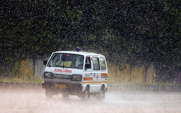 epa09518896 An ambulance drive along a road during heavy rain at Thiruvallur, on the outskirts of Chennai, India, 11 October 2021. The Indian Meteorological Department has predicted thunderstorms with moderate rain over some areas of Chennai and the suburbs for the coming days. The Tamil Nadu Water Resources Department on 10 October 2021 issued a flood alert in Chennai suburbs following heavy rains as the Poondi reservoir is expected to reach its full capacity.  EPA/IDREES MOHAMMED