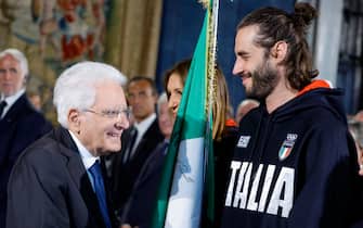 Il Presidente della Repubblica Sergio Mattarella (S) e Gianmarco Tamberi durante la cerimonia di restituzione della Bandiera degli atleti italiani di ritorno dai Giochi Olimpici e Paralimpici di Parigi 2024, Quirinale, Roma 23 settembre 2024. ANSA/FABIO FRUSTACI