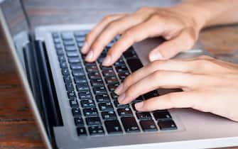Soft young female hands typing on a modern computer keyboard
