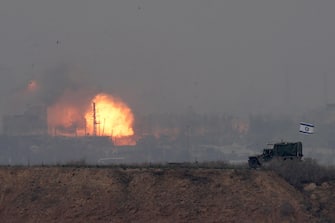 epa11011897 An explosion (background) after an airstrike as Israeli military vehicles (foreground) move at the border with the Gaza Strip, in southern Israel, 05 December 2023. Israeli forces resumed military strikes on Gaza after a week-long truce ended on 01 December. More than 15,500 Palestinians and at least 1,200 Israelis have been killed, according to the Palestinian Ministry of Health and the Israel Defense Forces (IDF), since Hamas militants launched an attack against Israel from the Gaza Strip on 07 October, and the Israeli operations in Gaza and the West Bank which followed it  EPA/ATEF SAFADI