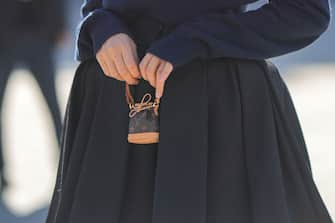 PARIS, FRANCE - OCTOBER 04: Xenia Adonts wears a navy blue wool studded pullover from Louis Vuitton, a high waist black pleated puffy short skirt from Louis Vuitton, a brown LV monogram in coated canvas micro handbag from Louis Vuitton, outside Louis Vuitton, during Paris Fashion Week - Womenswear Spring/Summer 2023, on October 04, 2022 in Paris, France. (Photo by Edward Berthelot/Getty Images)