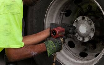 Mechanic removing a bus wheel with an impact wrench