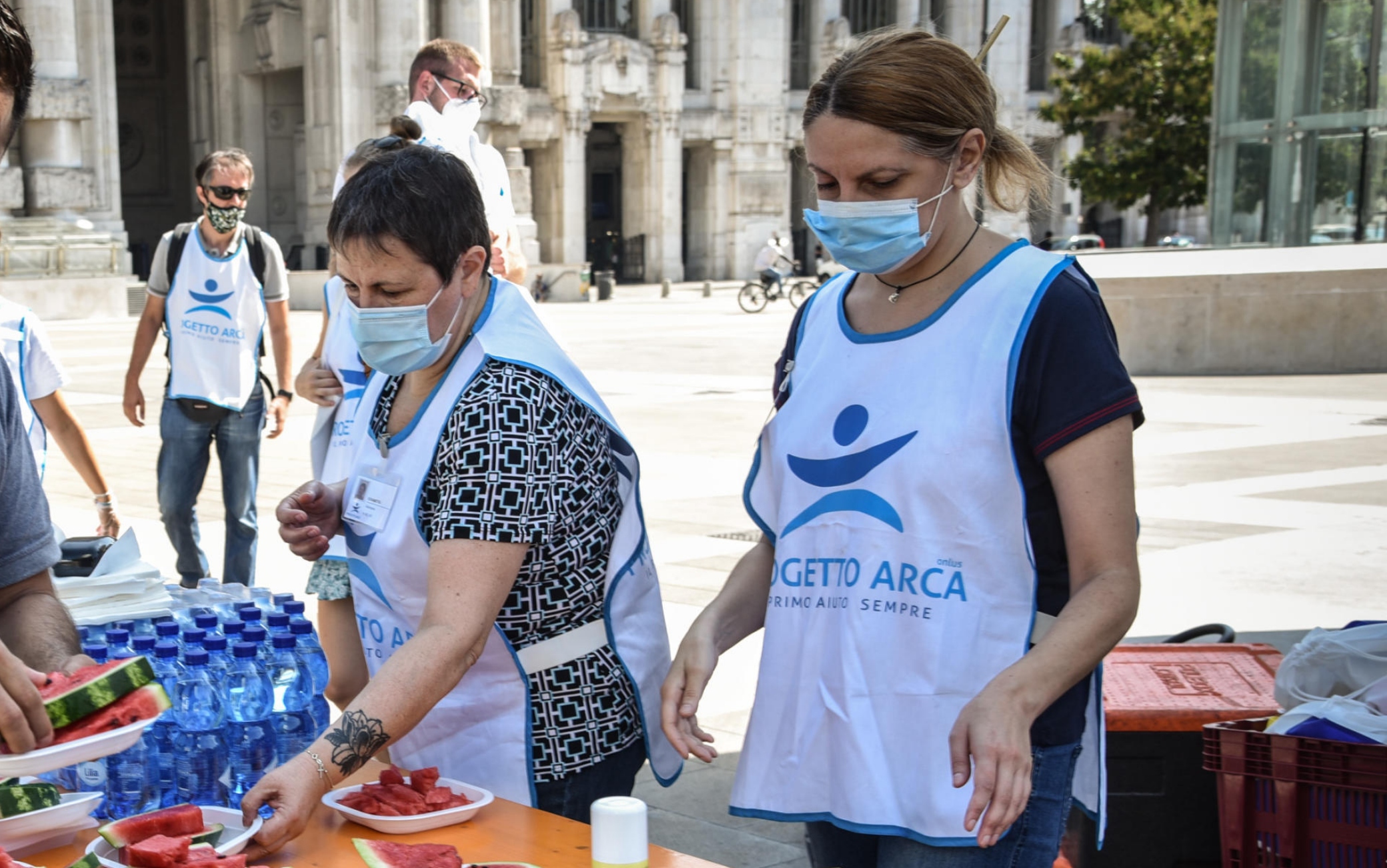 Distribuzione di anguria fresca e bottigliette d’acqua ai senzatetto dai volontari del Progetto Arca in piazza duca d’aosta davanti alla stazione Centrale