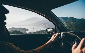 Man driving a car near the sea.