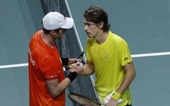 epa10321531 Australian tennis player Alex de Minaur (R) salutes Dutch Botic van de Zandschulp (L) at the end of their Davis Cup quarter final tie between Australia and Netherlands in Malaga, southern Spain, 22 November 2022.  EPA/JULIO MUNOZ