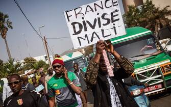 A group of demonstrators, one holding a placard that reads "France divides Mali", marching towards the French Embassy in Bamako to protest against the ongoing presence of the French Forces in Mali, on January 10, 2018. 
On January 11, 2013 the Operation Serval was launched by the French Military, a campaign aimed at ousting Islamic militants from the north of Mali, who had begun a push into the center of Mali.  / AFP PHOTO / Michele CATTANI        (Photo credit should read MICHELE CATTANI/AFP via Getty Images)
