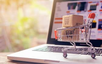 Shopping online concept - Parcel or Paper cartons with a shopping cart logo in a trolley on a laptop keyboard. Shopping service on The online web. offers home delivery.