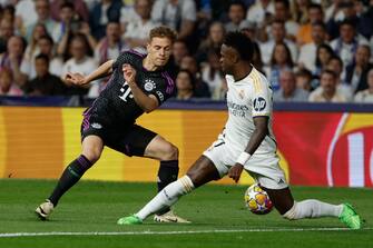 epa11327727 Real Madrid's Vinicius Jr. (R) in action against Bayern Munich's Joshua Kimmich during the UEFA Champions League semifinal second leg soccer match between Real Madrid and Bayern Munich, in Madrid, Spain, 08 May 2024.  EPA/J.J. Guillen