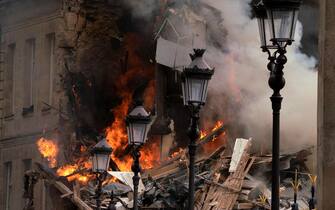 Smoke billows from rubbles of a building at Place Alphonse-Laveran in the 5th arrondissement of Paris, on June 21, 2023. A major fire of unknown origin broke out on June 21, 2023 in a building in central Paris, part of which collapsed, injuring at least one person, according to sources and AFP images. (Photo by ABDULMONAM EASSA / AFP) (Photo by ABDULMONAM EASSA/AFP via Getty Images)