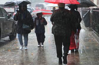 NEW YORK, NEW YORK - SEPTEMBER 29: People walk under umbrellas amid heavy rain on September 29, 2023 in the Flatbush neighborhood of Brooklyn borough New York City. Flash flooding is expected in the counties of Nassau, Queens and Kings, which includes Brooklyn, according to the stateâ  s National Weather Service office as remnants of Tropical Storm Ophelia reaches the Northeast.  (Photo by Michael M. Santiago/Getty Images)