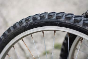 Close up of a mountain bike wheel with rusty spokes