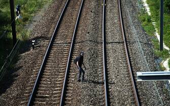 A man walks on train rails amid a demonstration against the construction of a high-speed rail line between Lyon and Torino, in La Chapelle, near Modane, in the French Alps' Maurienne valley, on June 17, 2023. Hundreds of oponents to the Lyon-Torino high-speed rail line demonstrated on June 17 despite a ban on the gathering, of which the details are yet to be determined and despite a heavy police presence in the valley. They set up a makeshift camp on land lent by the municipality of La Chapelle, outside the ban zone announced the day before by the Savoie prefecture. (Photo by OLIVIER CHASSIGNOLE / AFP) (Photo by OLIVIER CHASSIGNOLE/AFP via Getty Images)