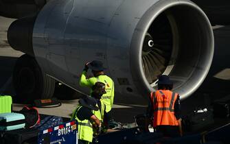 American Airlines ramp workers wear hats to protect themselves from the sun while loading bags onto an aircraft on the tarmac at Phoenix Sky Harbor International Airport (PHX) during a record heat wave in Phoenix, Arizona on July 18, 2023. (Photo by Patrick T. Fallon / AFP) (Photo by PATRICK T. FALLON/AFP via Getty Images)