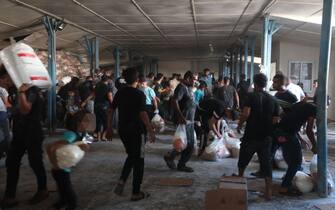 Palestinians storm a UN-run aid supply center, that distributes food to displaced families following Israel's call for more than one million residents in northern Gaza to move south for their safety, in Deir al-Balah on October 28, 2023, amid the ongoing battles between Israel and the Palestinian group Hamas. Thousands of civilians, both Palestinians and Israelis, have died since October 7, 2023, after Palestinian Hamas militants based in the Gaza Strip entered southern Israel in an unprecedented attack triggering a war declared by Israel on Hamas with retaliatory bombings on Gaza. (Photo by MOHAMMED ABED / AFP) / "The erroneous mention[s] appearing in the metadata of this photo by MOHAMMED ABED has been modified in AFP systems in the following manner: [Storm] instead of [Collect boxes and and bags from]. Please immediately remove the erroneous mention[s] from all your online services and delete it (them) from your servers. If you have been authorized by AFP to distribute it (them) to third parties, please ensure that the same actions are carried out by them. Failure to promptly comply with these instructions will entail liability on your part for any continued or post notification usage. Therefore we thank you very much for all your attention and prompt action. We are sorry for the inconvenience this notification may cause and remain at your disposal for any further information you may require." (Photo by MOHAMMED ABED/AFP via Getty Images)