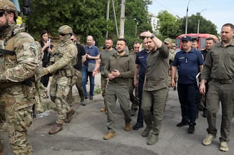 epa10679102 Ukrainian President Volodymyr Zelensky (C-L) speaks to Ihor Klymenko (C-R), head of the National Police of Ukraine, during a visit to Kherson, Ukraine, 08 June 2023, amid the Russian invasion. Ukraine has accused Russian forces of destroying a critical dam and hydroelectric power plant on the Dnipro River in the Kherson region along the front line in southern Ukraine on 06 June, leading to the flooding of a number of settlements.  EPA/MYKOLA TYMCHENKO