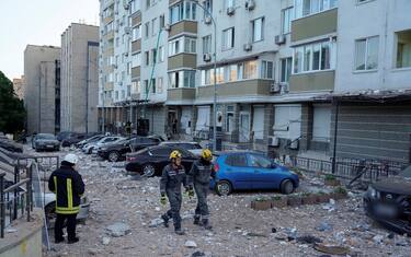 epa10662769 Rescue workers walk through rubble outside an apartment building after it was damaged during a drone strike in Kyiv (Kiev), Ukraine, 30 May 2023, amid the Russian invasion. At least one person died and three others were injured after a fire broke out in a multi-story building in the Ukrainian capital as a result of falling debris during a Russian strike, the Kyiv City Military Administration said on telegram. Russian troops entered Ukrainian territory in February 2022, starting a conflict that has provoked destruction and a humanitarian crisis.  EPA/Oleh Pereverziev