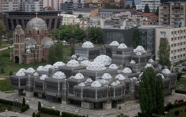 PRISTINA, KOSOVO - MAY 02: The unfinished Serbian Orthodox church of Christ the Savior is seen behind the national library of Kosovo on May 2, 2019 in Pristina, Kosovo. A recent EU-backed summit failed to restart negotiations between leaders from Kosovo and Serbia over a final resolution of Kosovo’s sovereignty. In previous talks, the countries’ presidents have signaled an openness to land swaps, which could see the majority-Serb areas north of the Ibar River annexed into Serbia. In the northern city of Mitrovica, the Ibar River divides the city, with Serbs dominating the north and ethnic Albanians to the south. In exchange for ceding areas above the Ibar, Kosovo would take the predominantly ethnic Albanian area of the Presevo Valley in southern Serbia. Many political leaders in Kosovo and across Europe are vehemently opposed to ethnic partition and land swaps, fearing that a change in borders could reignite a conflict that resulted in thousands of deaths from 1998 to 1999. During the conflict, Serbian forces started an ethnic cleansing campaign which pushed approximately one million predominantly muslim Kosovar Albanians from their homes. After diplomatic solutions failed, NATO intervened with a 78-day, United-States led bombing campaign to force Serbian troops to withdraw. After nine years under United Nations control, Kosovo declared independence from Serbia in 2008. Since the declaration, Kosovo has been recognized by 111 of the United Nation’s 193 member states. Serbia, Russia, China and five EU countries still do not recognize it, keeping the country into a state of limbo. (Photo by Chris McGrath/Getty Images)