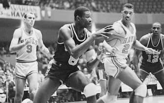(Original Caption) Chicago Packers Wally Bellamy, (#8) charges toward his end of the court after retrieving the ball from Hawks Bob Pettit, (#9), in the first quarter action here. Hawk Shellie McMillon, (#25) made an unsuccessful try for the ball. Packer Andy Johnson, (#12) is shown in the background.