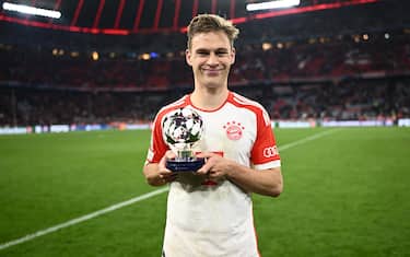 MUNICH, GERMANY - APRIL 17: Joshua Kimmich of Bayern Munich poses for a photo with the PlayStation Player Of The Match award after the team's victory during the UEFA Champions League quarter-final second leg match between FC Bayern MÃ¼nchen and Arsenal FC at Allianz Arena on April 17, 2024 in Munich, Germany. (Photo by Alexander Scheuber - UEFA/UEFA via Getty Images)