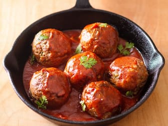 Food Homemade organic spicy meatball in iron cast on wooden background
