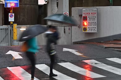 Alcune persone camminano riparandosi dalla pioggia con gli ombrelli a Genova, 8 ottobre 2024. Allagamenti diffusi sul territorio ligure. Scuole chiuse in via precauzionale in molti comuni, allerta arancione nel centro della regione, mentre nel Tigullio e nello spezzino il livello di allerta rossa per i grandi bacini dell'Entella e del Magra.
(pioggia,. maltempo, simbolica, pioggia, generica) 
ANSA/LUCA ZENNARO